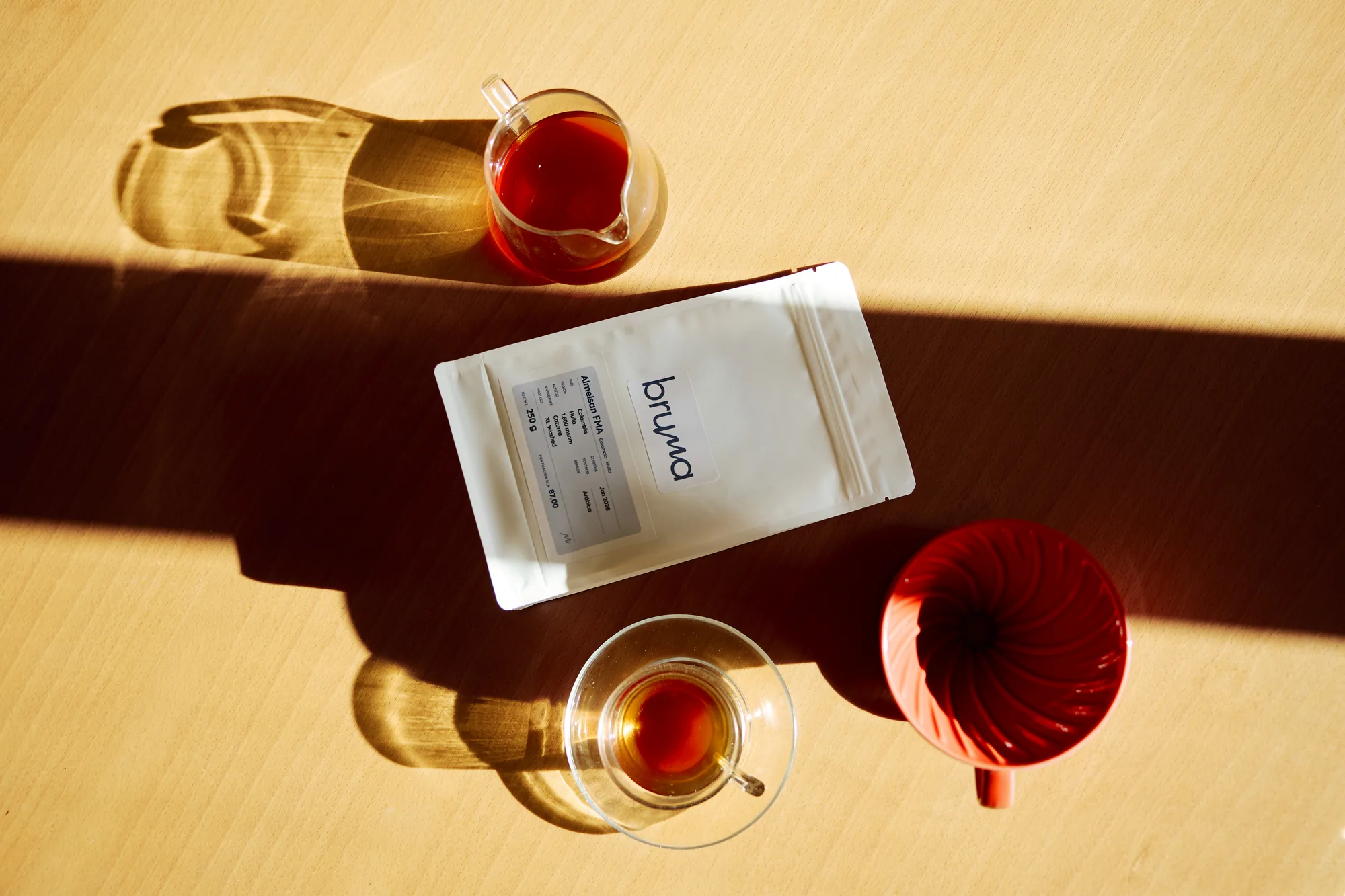 Café recién preparado, una jarra de cristal y una bolsa de café Bruma